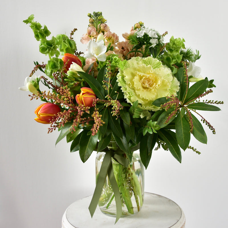 A pretty posy of seasonal blooms, in a mason jar tied with a bow.  Includes what&
