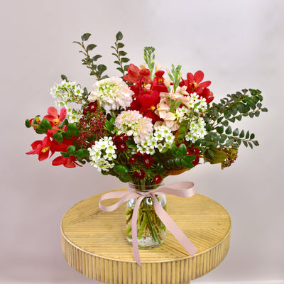 Seasonal Posy Jar with red orchids, box and other blooms.  the posy jar is a great gift when you want to spread joy without stress.  Online flower delivery available from The Branche florist.  Delivers throughout Melbourne especially servicing Ashburton, Ashwood, Glen Iris, Chadstone, Camberwell, Canterbury